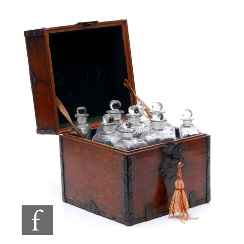 549 - An early 19th Century metal bound oak square decanter box, fitted with an arrangement of nine clear ... 