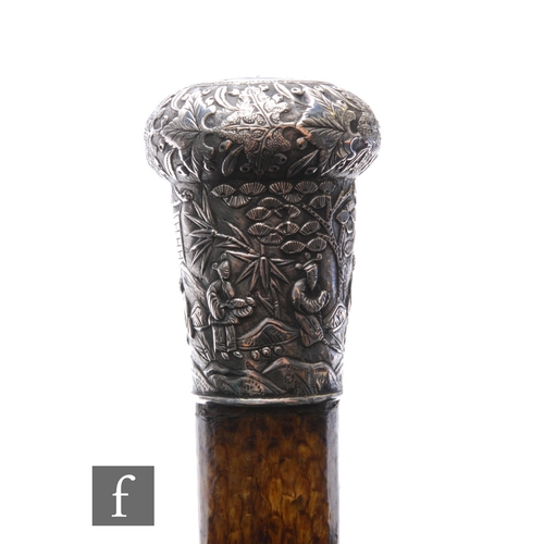 564 - An early 20th Century Chinese silver topped walking cane decorated with figures in a landscape setti... 