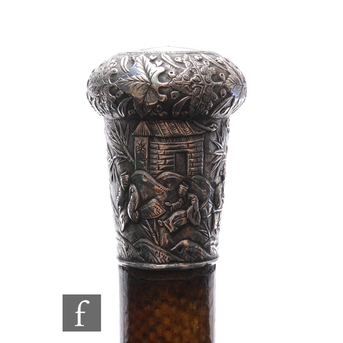 564 - An early 20th Century Chinese silver topped walking cane decorated with figures in a landscape setti... 