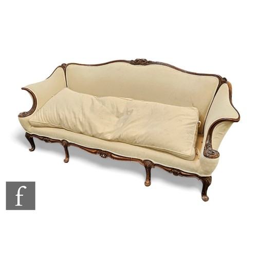 742 - An Edwardian mahogany framed three seater settee, undulating back and deep scroll arms on cabriole l... 