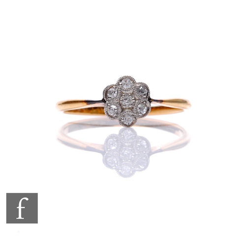 121 - An early 20th Century 18ct diamond daisy cluster ring, seven millgrain set stones to knife edged sho... 