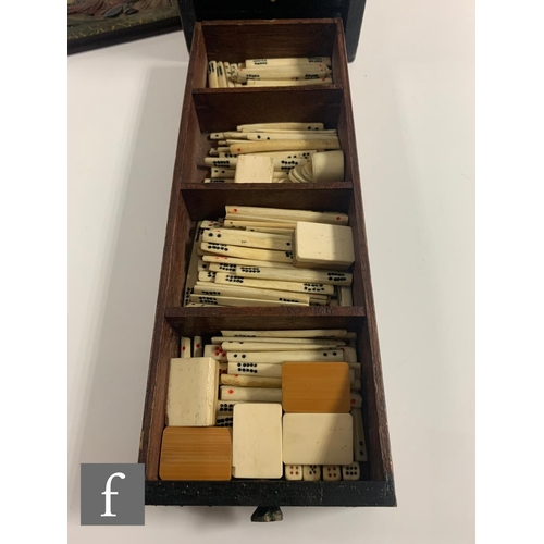 551 - A 1920s/30s bone mahjong set, the carved coloured case with sliding front door containing five drawe... 