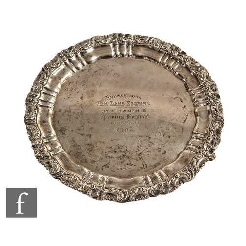 18 - A hallmarked silver circular salver with central presentation engravings within foliate scroll borde... 