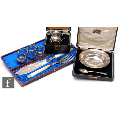 40 - A small parcel lot of assorted silver to include a cased bowl and spoon, a christening cup and napki... 