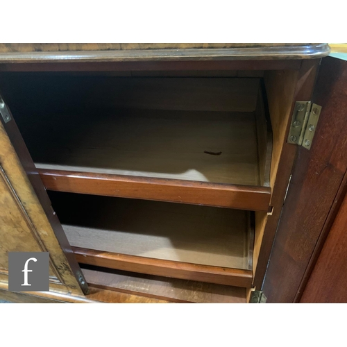 716 - A Victorian figured walnut linen cupboard enclosed by four moulded arched doors, fitted with sliding... 