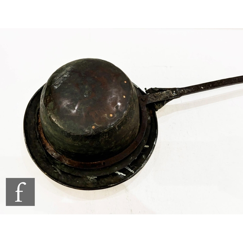 479 - A 17th Century brass warming pan, the domed centre engraved with scroll and leaf design and the oute... 