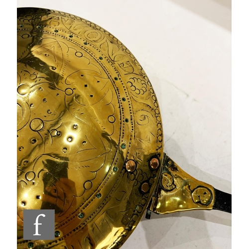 479 - A 17th Century brass warming pan, the domed centre engraved with scroll and leaf design and the oute... 