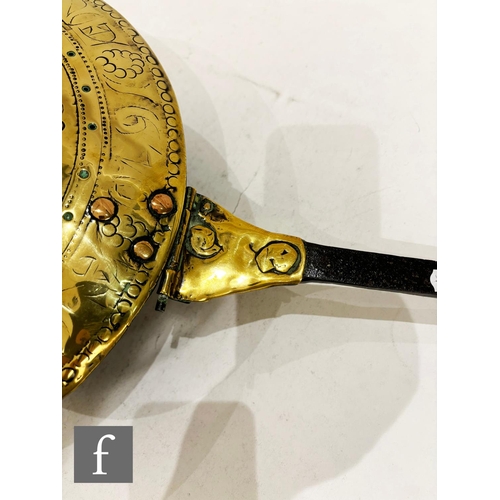 479 - A 17th Century brass warming pan, the domed centre engraved with scroll and leaf design and the oute... 