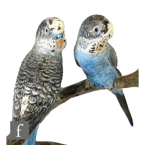 563 - An early 20th Century cold painted bronze study of three blue budgerigars perched to a branch above ... 