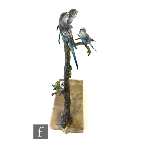 563 - An early 20th Century cold painted bronze study of three blue budgerigars perched to a branch above ... 