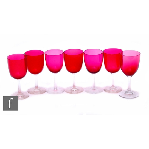 225 - A matched set of seven cranberry and clear stemmed wine glasses, height 10.5cm. (7)PLEASE VIEW CONDI... 