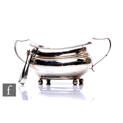 79 - A Georgian hallmarked silver boat shaped twin handled sugar basin with gadroon border and a pair of ... 