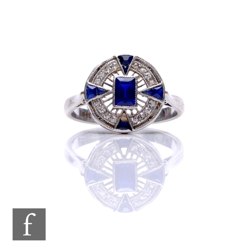 264 - An Art Deco 18ct white gold sapphire and diamond ring, circular head set with central emerald cut sa... 