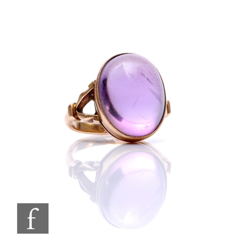 271 - A 9ct single stone amethyst ring, oval cabochon collar set stone, length 16mm, to split shoulders, w... 