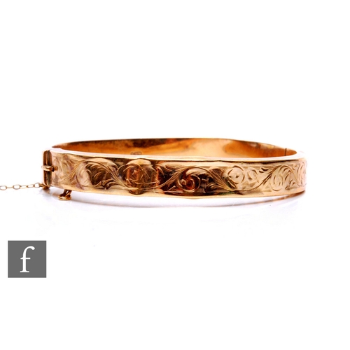 281 - A 9ct gold hinged bangle, engraved with foliate designs, stamped 375, total weight 10.6g, diameter 6... 