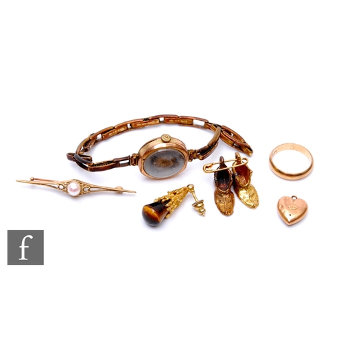 284 - A parcel lot of jewellery, to include a 9ct gold wedding band, size L, a small 9ct gold and tigers e... 