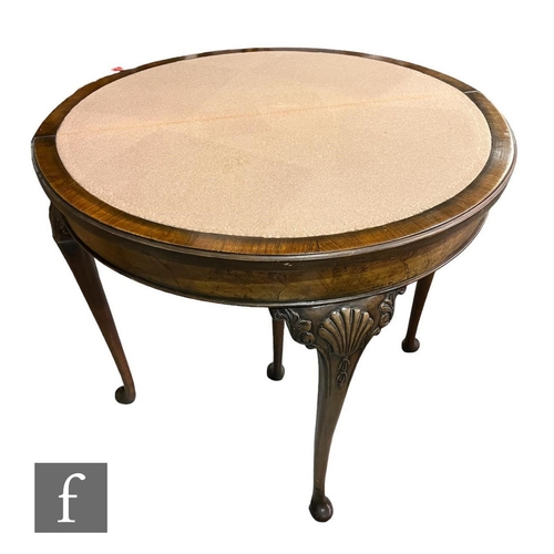 594 - A 1930s demi-lune fold over burr walnut card table, the carved edge over a baize interior on cabriol... 