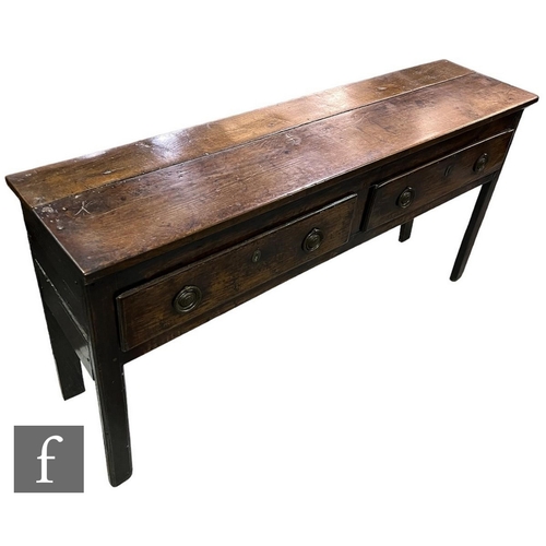 596 - A small late 18th and early 19th Century oak two drawer dresser, the plank top over conforming panel... 