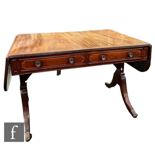 619 - A Regency rosewood crossbanded mahogany sofa table, fitted with two drawers, circular handles on spl... 