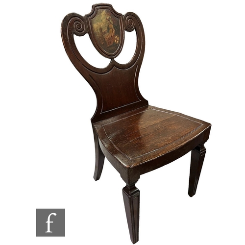 640 - A Regency Irish mahogany hall chair, the pierced scroll panel centred with a shield painted with a s... 