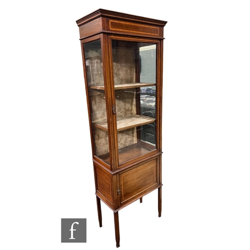 644 - An Edwardian inlaid mahogany display cabinet of narrow proportions, the fitted shelf interior enclos... 