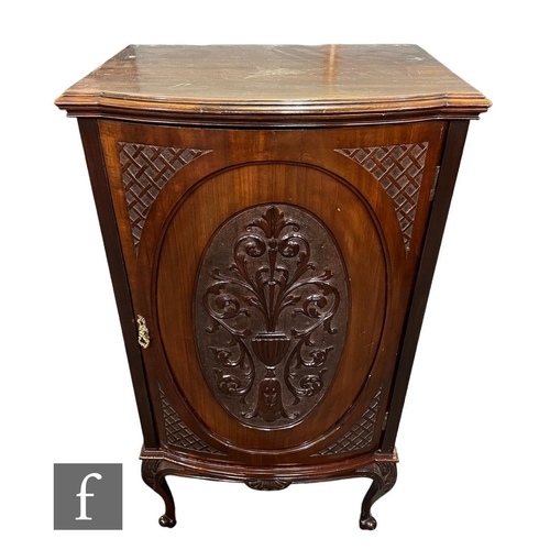 636 - A late Victorian carved mahogany bowfront bedside cabinet enclosed by an oval panel door below a mou... 