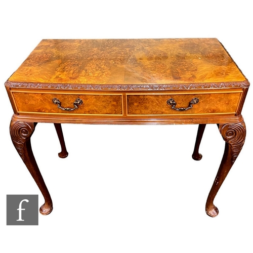 599 - A Queen Anne style figured walnut carved bow front side table fitted with two drawers, on leaf carve... 