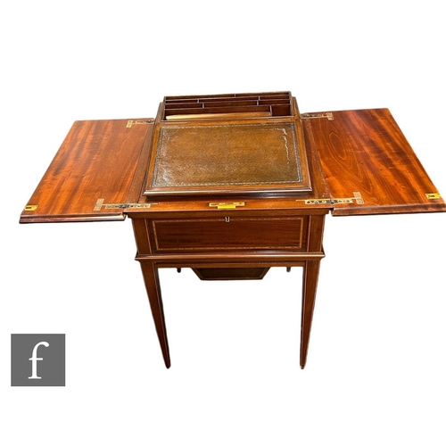 629 - An Edwardian crossbanded mahogany writing table, the hinged flap top opening to reveal a rise and fa... 