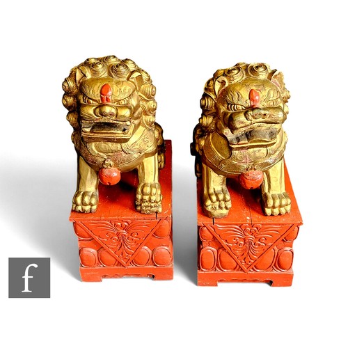 643 - A pair of early 20th Century Chinese carved Manchu temple dogs, each seated with paws to the front a... 