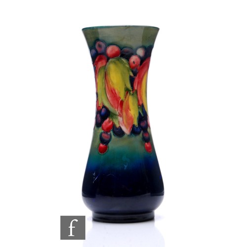 77 - William Moorcroft - A Moorcroft Pottery Leaf and Berry vase, elongated baluster form, tubeline decor... 