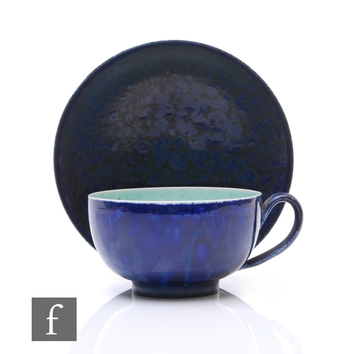 112 - Ruskin Pottery - An eggshell cup and saucer, dark blue oxidised glaze and flecked celadon glazed int... 