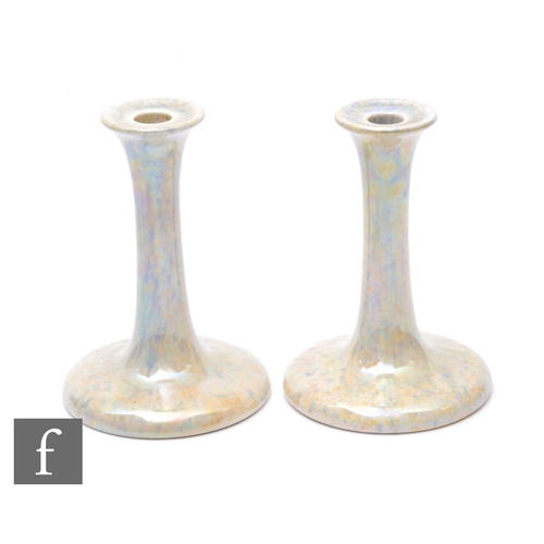 123 - Ruskin Pottery - A pair of candlesticks, with wide spreading circular foot and tall swept column and... 