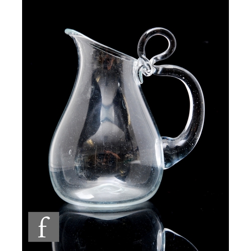 359 - A late 19th Century Arts and Crafts glass jug of ovoid form, with applied loop handle, height 14cm.