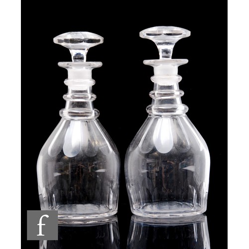 427 - A pair of Prussian form decanters, each with slice cut shoulders above basal slice cuts and a three ... 