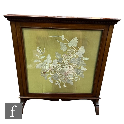 577 - An Edwardian mahogany firescreen, panelled back and embroidered floral spray front on a pale green g... 