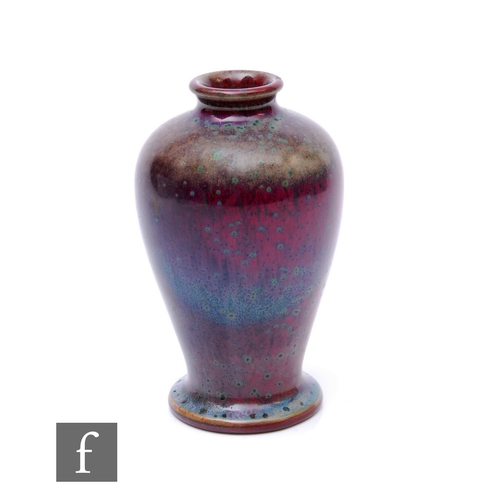 130 - Ruskin Pottery - A small 1930s high fired vase of inverse baluster form, decorated in a high fired r... 