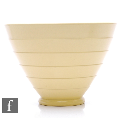 585 - Keith Murray - Wedgwood - An Art Deco straw glazed conical bowl, relief moulded with overlapped conc... 