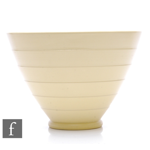 587 - Keith Murray - Wedgwood - An Art Deco straw glazed conical bowl, relief moulded with overlapped conc... 