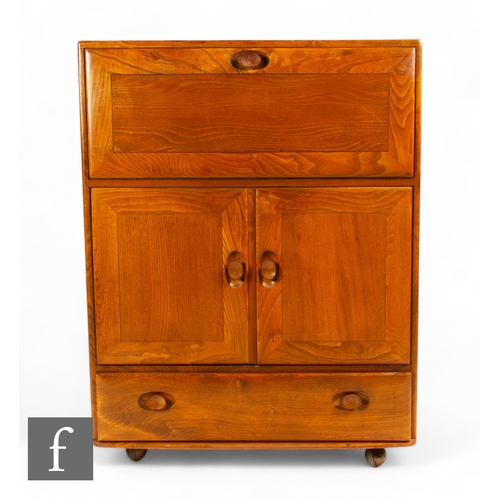 911 - Ercol - A mid century model 469 'Windsor' drinks cabinet/bureau, the fall front above twin cabinet d... 