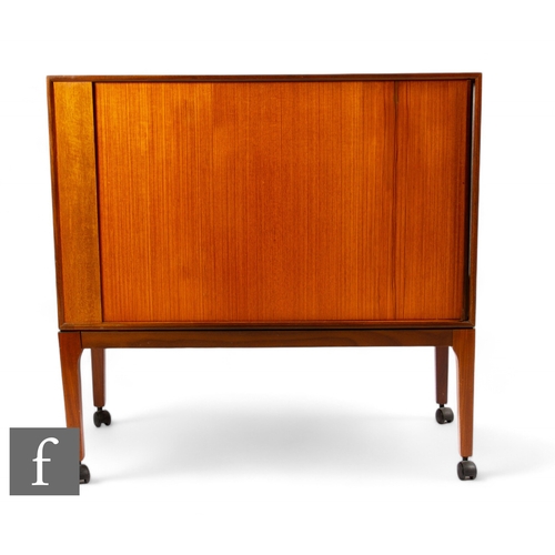 917 - Remploy - A mid century 1960s teak cabinet, raised on tapered block supports with sliding door, stam... 