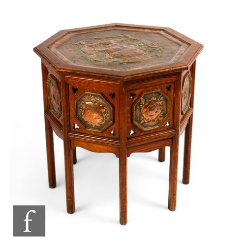 67A - Unattributed maker - An Arts & Crafts octagonal occasional table, with hammered copy heraldic in... 