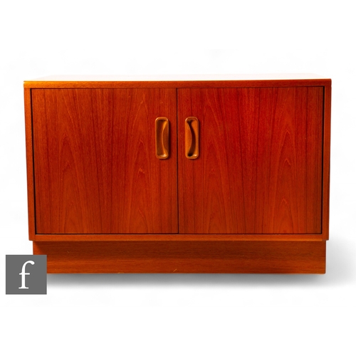 930 - G-Plan - A small mid Century teak cabinet, the twin doors with cupped handles, revealing single shel... 