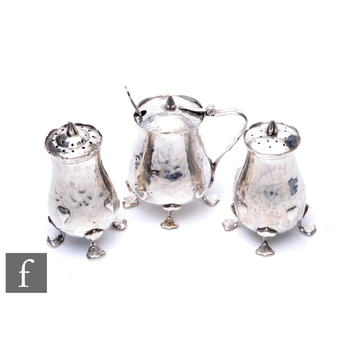 33 - Oliver Baker - Liberty & Co - A hallmarked silver Cymric cruet set, comprising mustard, salt and... 