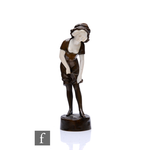 696 - Peter Tereszczuk (1875-1963) - A small 1920s bronze and ivory figure modelled as a lady in mop cap a... 