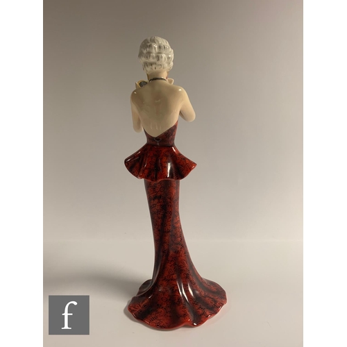 615 - Josef Lorenzl - Goldscheider - A figure of a lady, wearing fitted red and black floral patterned eve... 