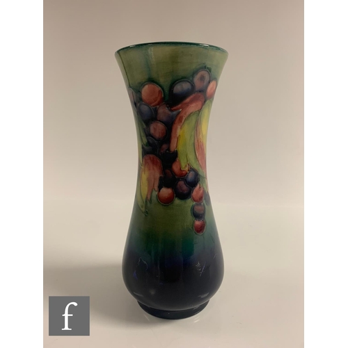 77 - William Moorcroft - A Moorcroft Pottery Leaf and Berry vase, elongated baluster form, tubeline decor... 