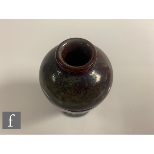 130 - Ruskin Pottery - A small 1930s high fired vase of inverse baluster form, decorated in a high fired r... 