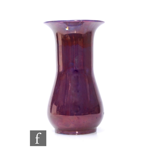 96 - William Moorcroft - A large vase of baluster form decorated in a deep purple glaze with flambe red s... 