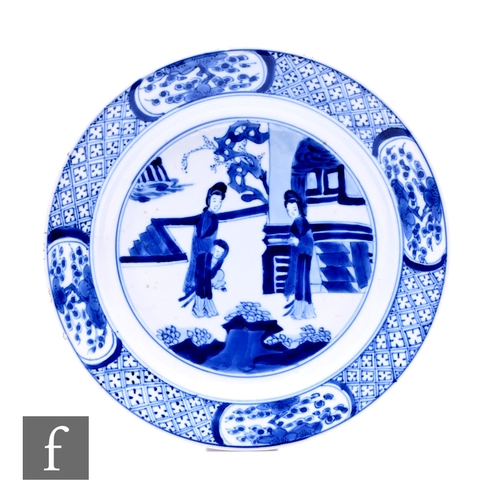 463 - A Chinese blue and white Kangxi period dish, of circular form, decorated with figures amongst formal... 