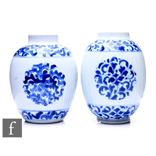 482 - A matched pair of Chinese Kangxi period (1661-1722) blue and white ovoid form vases, each of ribbed ... 